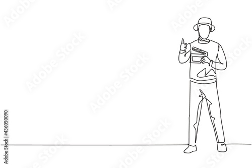 Single continuous line drawing film director stands with a thumbs-up gesture while holding the clapperboard to prepare the camera crew for shooting. One line draw graphic design vector illustration.