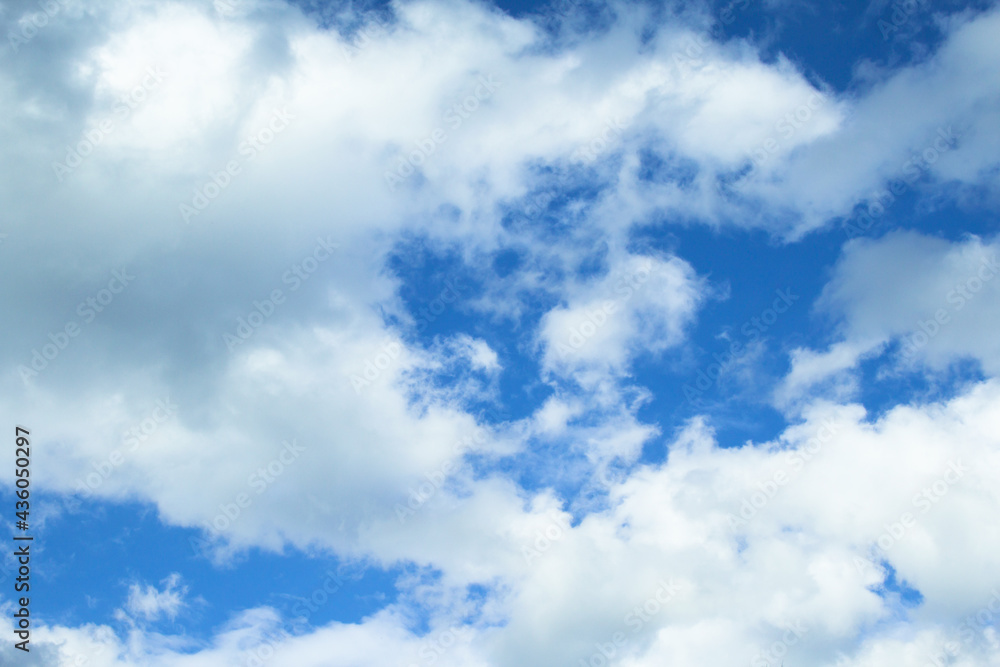 Beautiful white clouds against a blue sky, copy space. Blue sky with clouds, free space. Texture. The background. The sun shines through the clouds. Beautiful white clouds against a blue sky, copy space. Blue sky with clouds, free space. Texture. The background. The sun shines through the clouds.