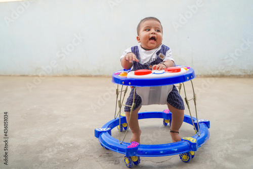 Cheerful Indian child in the baby walker. photo
