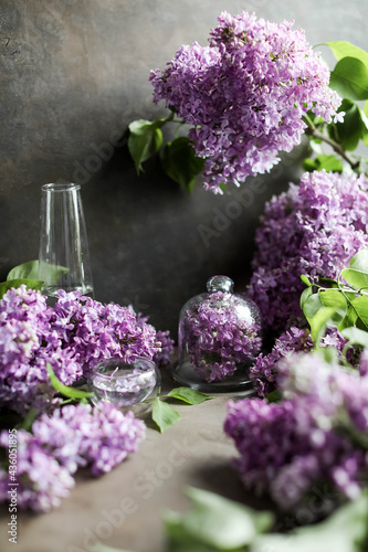 Cinnamon rolls on the table with white lilacs. Breakfast with rolls and milk.