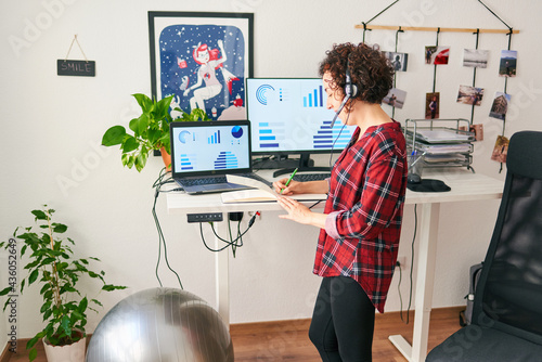 Woman telecommuting at an adjustable standing desk photo