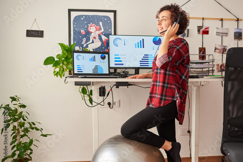 Woman telecommuting at an adjustable standing desk photo