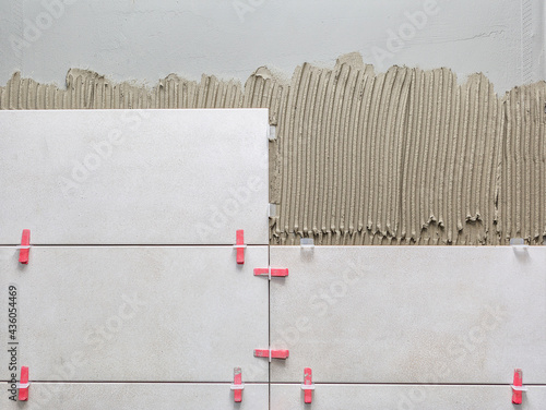 Photography Ceramic wall tile in position over adhesive with lash tile leveling system