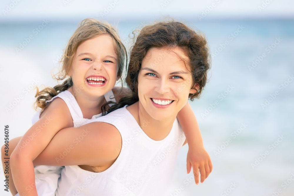 Portrait of happy mother and little daughter on ocean beach on Maldives at summer vacation. Family on the beach concept. Portrait of happy mother and little daughter on ocean beach on Maldives at summer vacation. Family on the beach concept.
