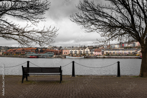An empty bench looking out to the canal on a cold winter day in the city of Bristol, England