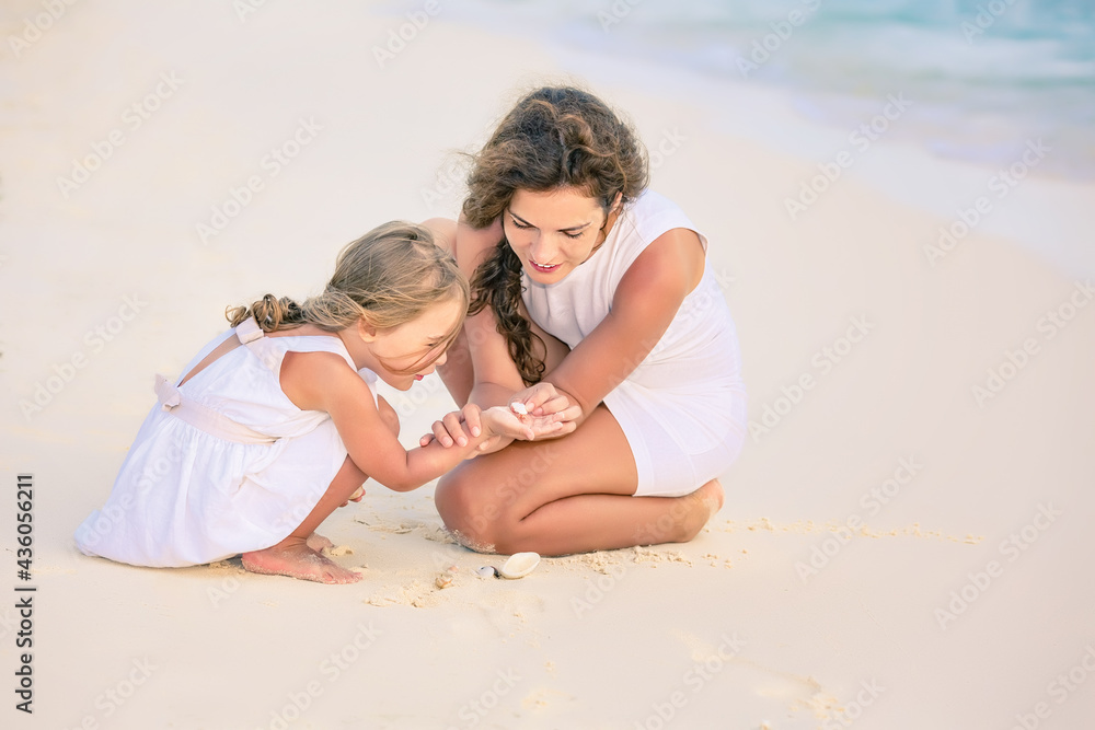 Mother with little daughter playing on ocean beach, Maldives. Family on the beach concept. Mother with little daughter playing on ocean beach, Maldives. Family on the beach concept.