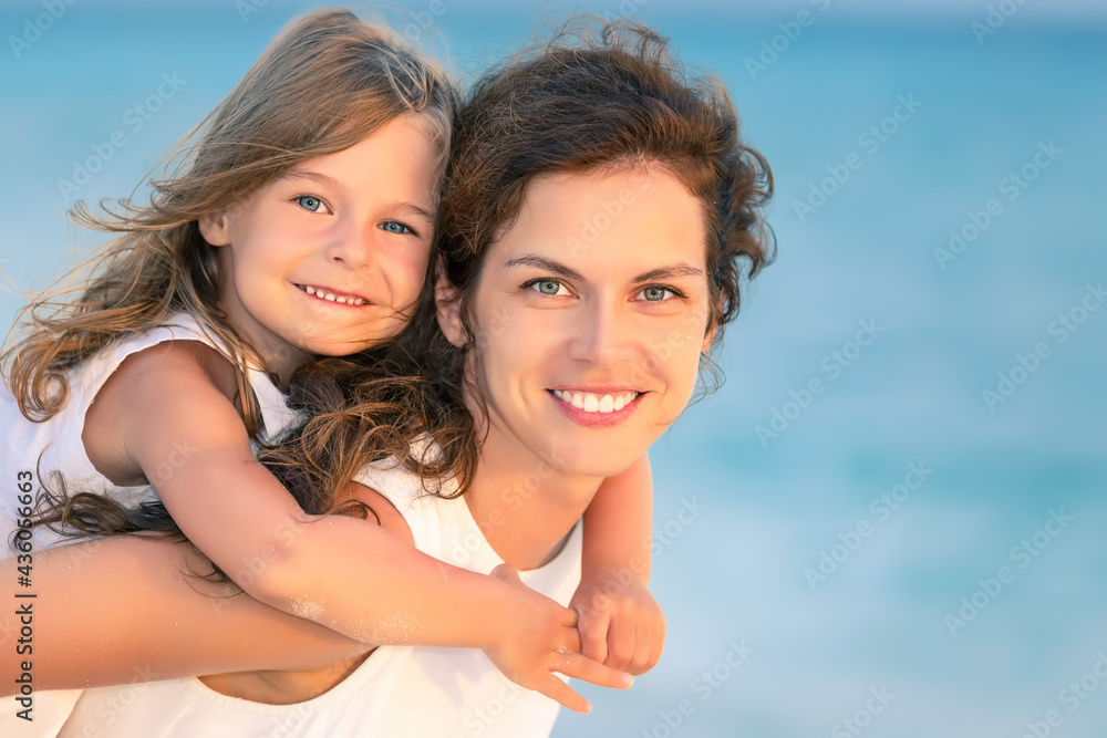 Portrait of happy mother and little daughter on ocean beach on Maldives at summer vacation. Family on the beach concept. Portrait of happy mother and little daughter on ocean beach on Maldives at summer vacation. Family on the beach concept.