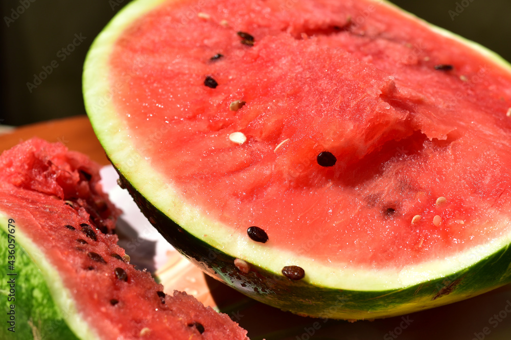 The picture shows two parts of a ripe watermelon on the table.