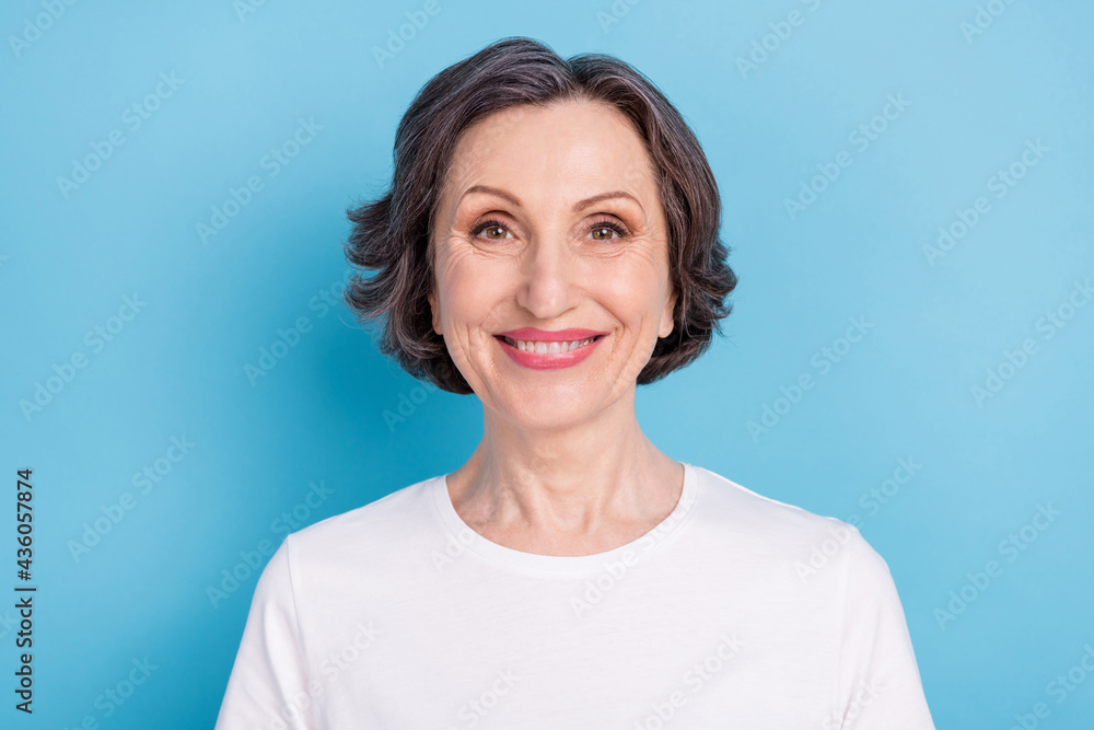 Portrait of attractive cheerful content grey-haired woman employee isolated over vibrant blue color background Portrait of attractive cheerful content grey-haired woman employee isolated over vibrant blue color background