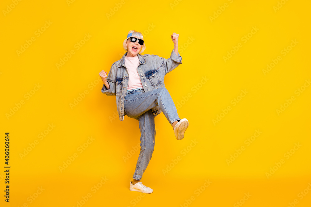 Full length body size view of attractive elderly cheerful woman rejoicing dancing having fun isolated over bright yellow color background Full length body size view of attractive elderly cheerful woman rejoicing dancing having fun isolated over bright yellow color background