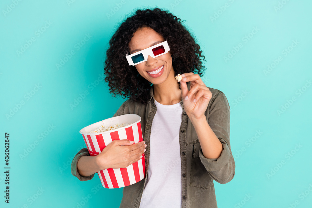 Obraz premium Portrait of attractive cheerful girl eating throwing corn having fun free time isolated over bright blue color background