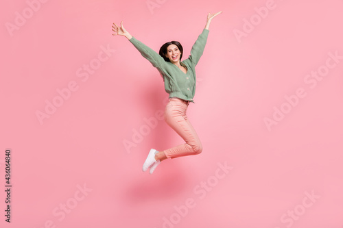 Full length body size view of attractive cheerful girl jumping having fun isolated over pink pastel color background