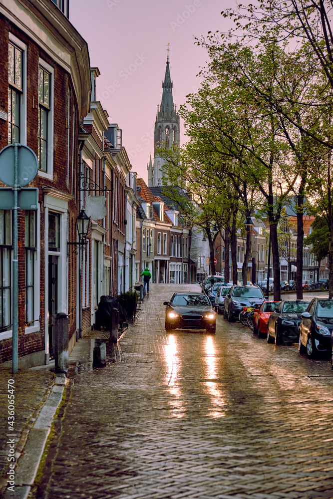 Delft cobblestone street with car in the rain