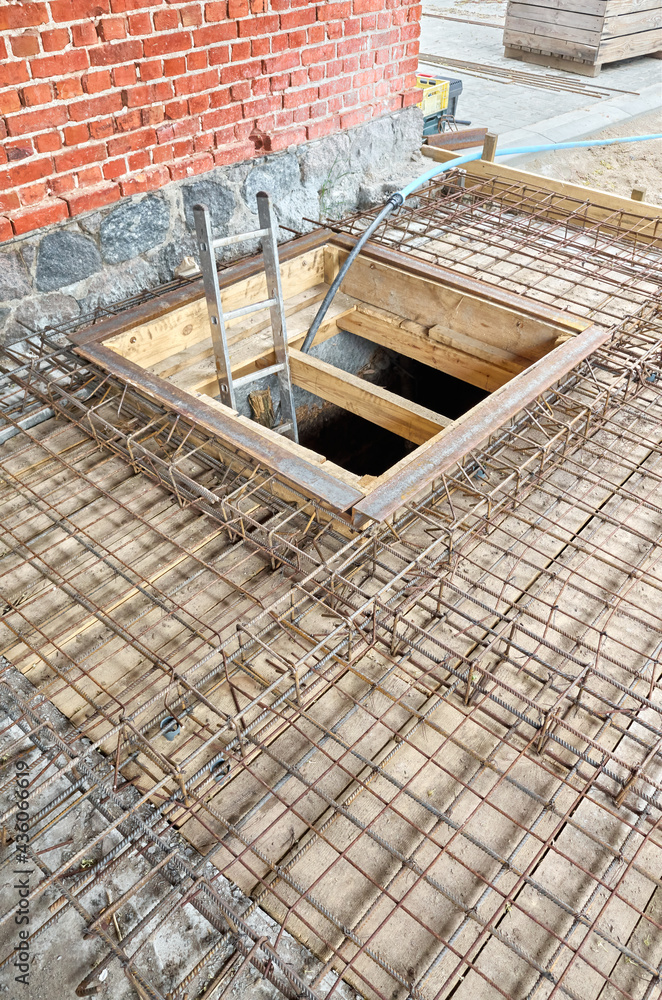 Cellar entrance surrounded by ribbed steel bar reinforcement construction frame ready for concrete casting. Cellar entrance surrounded by ribbed steel bar reinforcement construction frame ready for concrete casting.