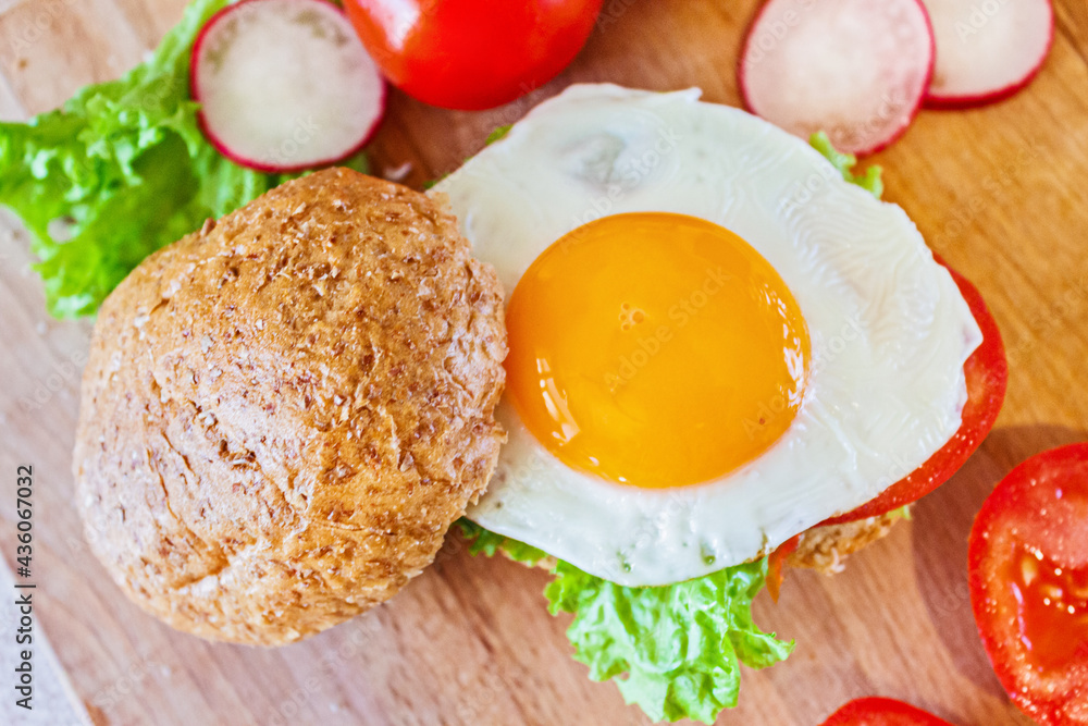 A healthy breakfast. Bun with lettuce, tomatoes and egg. A healthy breakfast. Bun with lettuce, tomatoes and egg.
