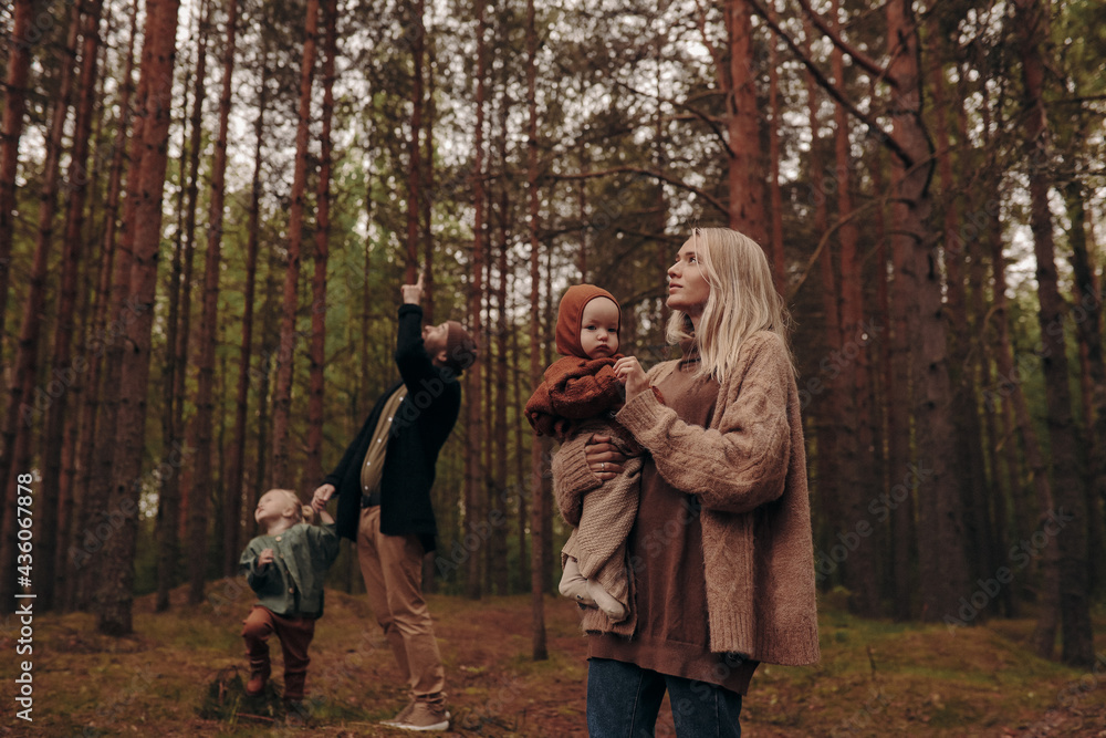 Fototapeta premium Happy family with children on a walk in the park among the trees.