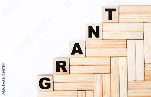 On a light background, wooden blocks and cubes with the text GRANT photo