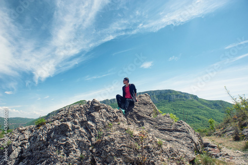 A young man is sitting on the rocks in Si  evo  Sicevo  Sicevo gorge 