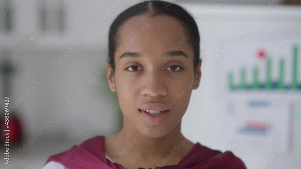 Close-up face of slim beautiful young African American woman taking off Covid-19 face mask sighing and looking at camera smiling. Headshot portrait of confident gorgeous lady posing in home office Close-up face of slim beautiful young African American woman taking off Covid-19 face mask sighing and looking at camera smiling. Headshot portrait of confident gorgeous lady posing in home office