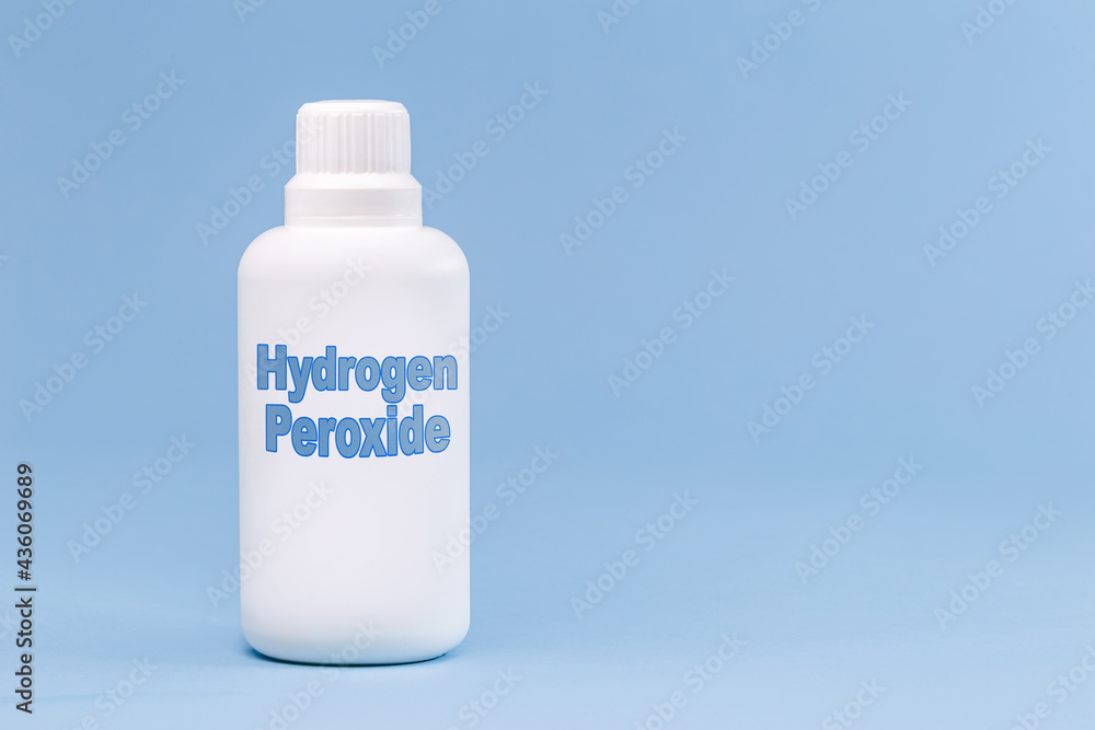 plastic container, medicine bottle, written in english: hydrogen peroxide, isolated blue background, concept of first care plastic container, medicine bottle, written in english: hydrogen peroxide, isolated blue background, concept of first care