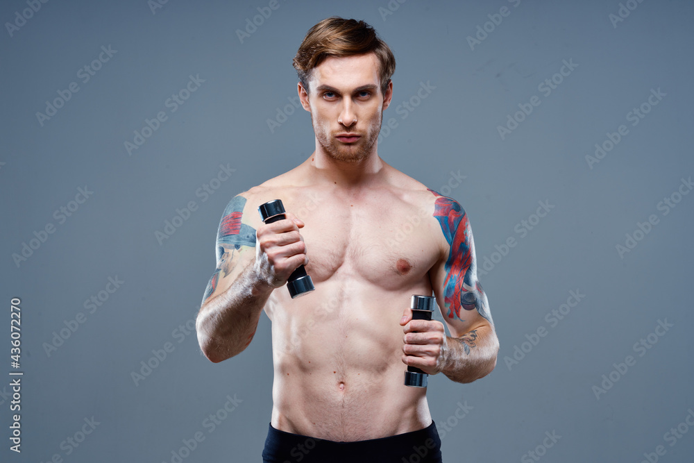 nude man doing sports on gray background and dumbbell tattoo cropped view nude man doing sports on gray background and dumbbell tattoo cropped view