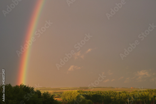 a bright rainbow in a gloomy sky after rain