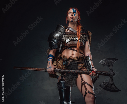 Photo Mediaeval woman viking posing in dark background with an axe
