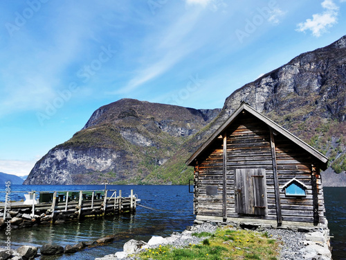 Beautiful wooden house on the shore of a lake and mountains in the background in Undredal, Norway photo