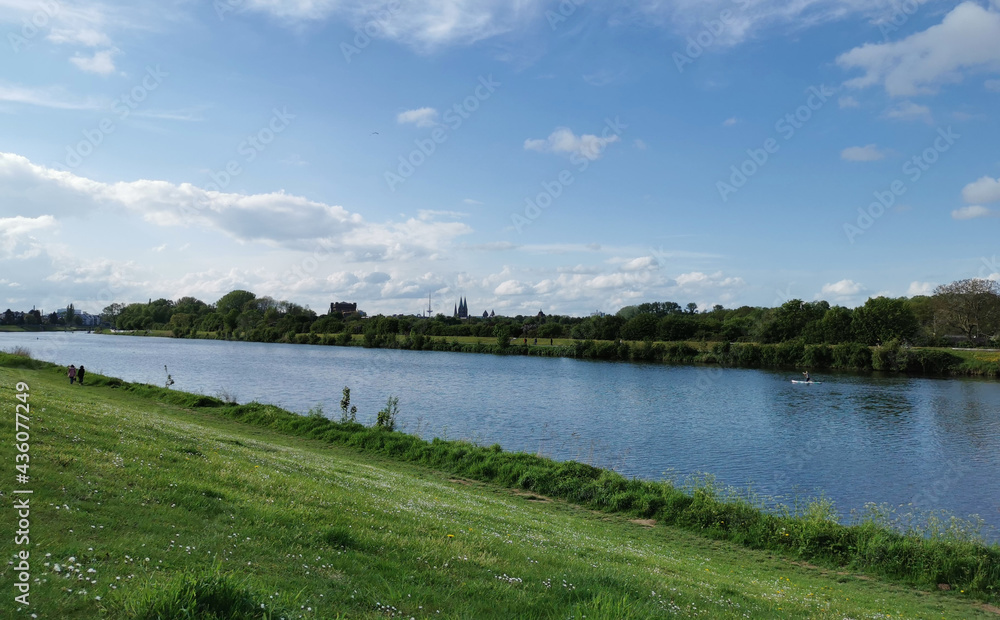 Bremen-Neustadt, Germany - May 16 2021: Lake Werdersee in sunny spring weather. Sights in background: Dom, Umgedrehte Kommode, Television tower Walle. Rowing boat track in foreground.