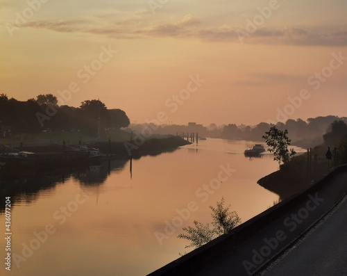 Bremen, Germany - September 15 2020: Weser river flowing along Schlachte and Osterdeich promenade in morning dawn. Beautiful sky between Neustadt and City of Bremen. Maritime life awakening.