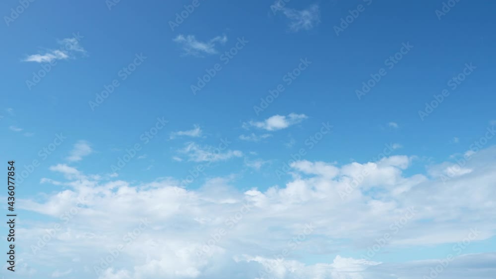 Dense white clouds cover the blue sky on a summer cloudy day. Dense white clouds cover the blue sky on a summer cloudy day.