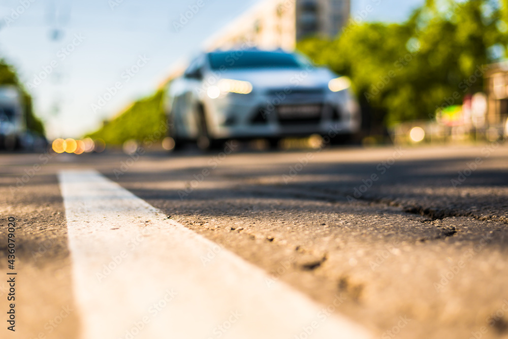 Sunny day in a city, view of the approaching car to the road level Sunny day in a city, view of the approaching car to the road level