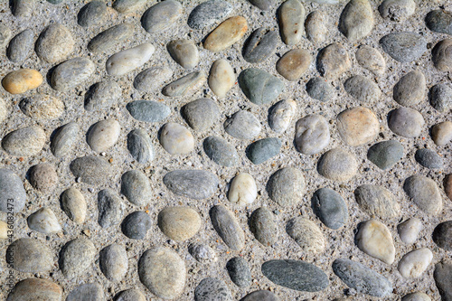 Round cobblestone (pebble) in concrete, street (road) pavement, close-up