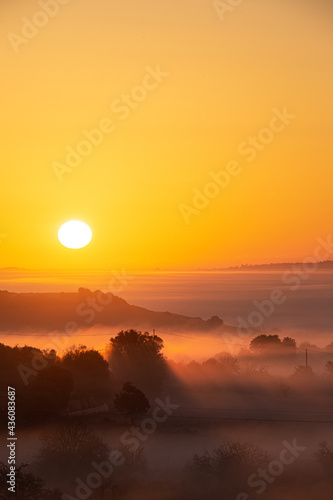 orange sunrise between the fog