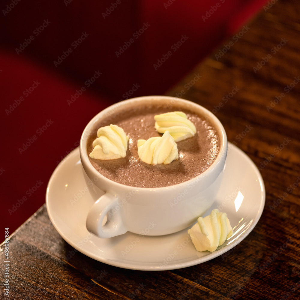 Cup of coffee and dessert. Mug of aromatic cappuccino with pieces of marshmallows on wooden table. Square format, soft focus. Copy space. Cup of coffee and dessert. Mug of aromatic cappuccino with pieces of marshmallows on wooden table. Square format, soft focus. Copy space.