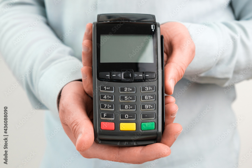 POS terminal or credit card reader machine on the white table with copy space. POS terminal or credit card reader machine on the white table with copy space.