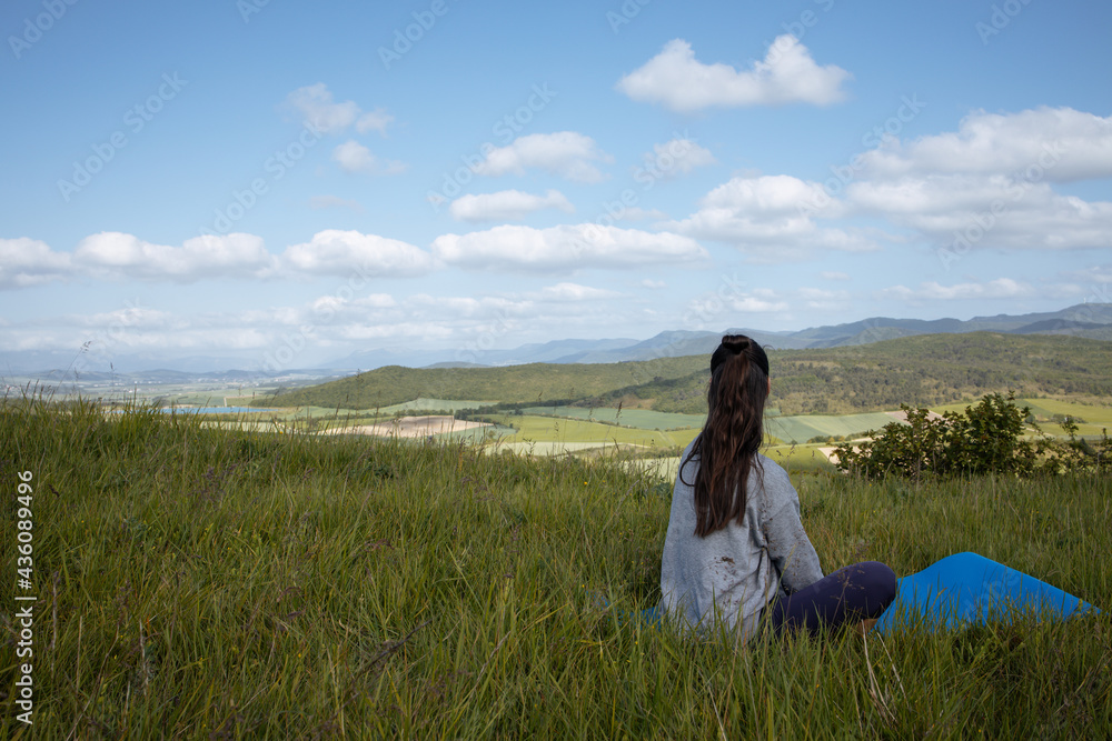 Young woman yoga outdoors keep calm and meditates while practicing yoga