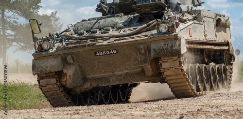 british army FV510 Warrior light infantry fighting vehicle tank kicking up dirt in action on a military exercise Wiltshire UK