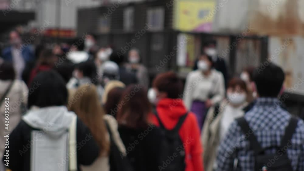 OSAKA, JAPAN - APRIL 2021 : Crowd of people wearing surgical masks to protect from Coronavirus (COVID-19) at the street in busy rush hour. View of commuters after work around Osaka train station. OSAKA, JAPAN - APRIL 2021 : Crowd of people wearing surgical masks to protect from Coronavirus (COVID-19) at the street in busy rush hour. View of commuters after work around Osaka train station.