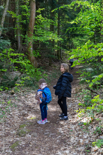 Little girl walking in the forest with her brother.