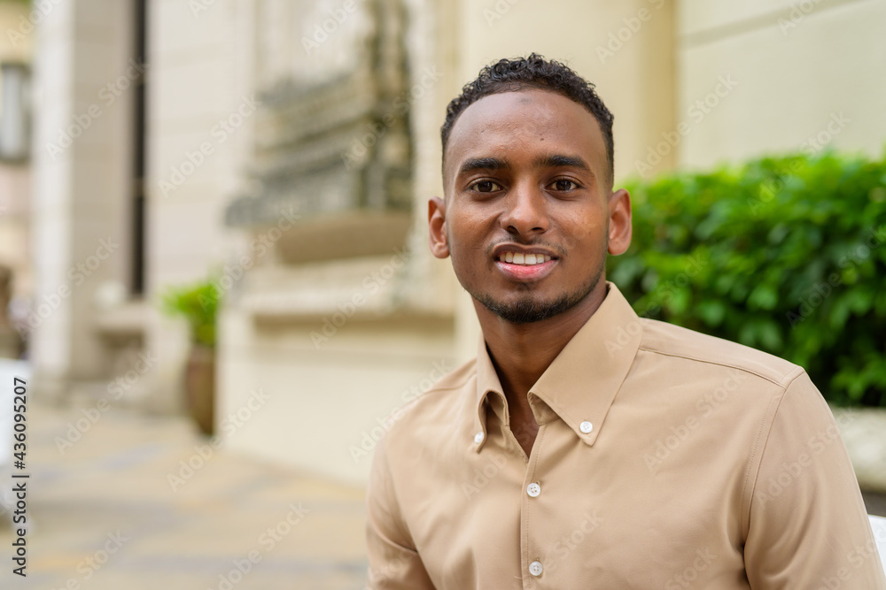 African businessman outdoors in city smiling and looking at camera African businessman outdoors in city smiling and looking at camera