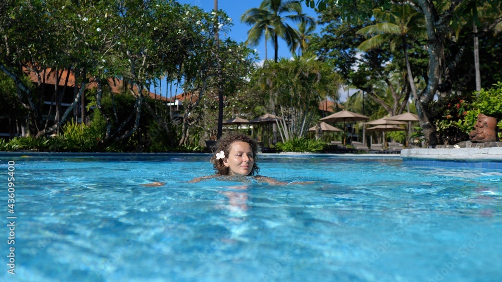 Dream travel destinations. Beautiful woman enjoying her swim alone in a pool of a five star hotel 