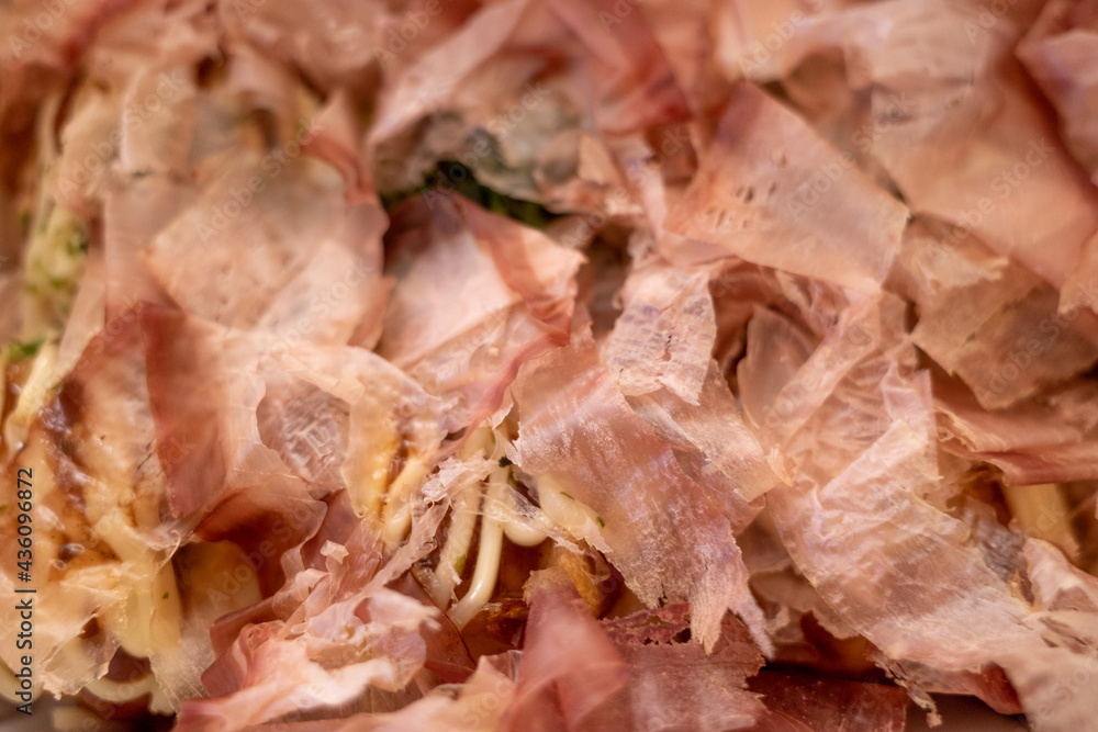 Close up and macro view at katsuobushi, bonito flake which on top of Takoyaki or Japanese octopus balls, serve on white paper box. Close up and macro view at katsuobushi, bonito flake which on top of Takoyaki or Japanese octopus balls, serve on white paper box.