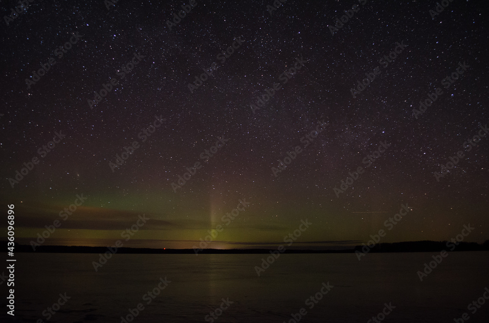 Northern lights aurora borealis over pond in Latvia.