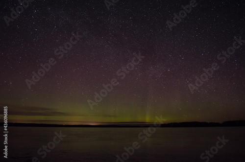 Northern lights aurora borealis over pond in Latvia.