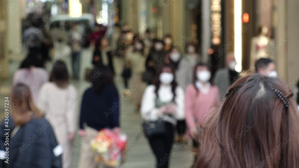 OSAKA, JAPAN - APRIL 2021 : Crowd of people wearing surgical masks to protect from Coronavirus (COVID-19) at Namba, Shinsaibashi shopping street. Slow motion shot. OSAKA, JAPAN - APRIL 2021 : Crowd of people wearing surgical masks to protect from Coronavirus (COVID-19) at Namba, Shinsaibashi shopping street. Slow motion shot.