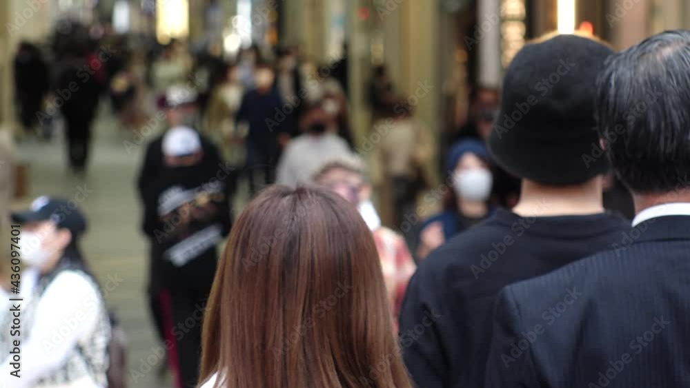 OSAKA, JAPAN - APRIL 2021 : Crowd of people wearing surgical masks to protect from Coronavirus (COVID-19) at Namba, Shinsaibashi shopping street. Slow motion shot. OSAKA, JAPAN - APRIL 2021 : Crowd of people wearing surgical masks to protect from Coronavirus (COVID-19) at Namba, Shinsaibashi shopping street. Slow motion shot.