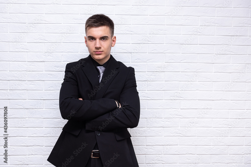 Male businessman on a white brick wall background Male businessman on a white brick wall background