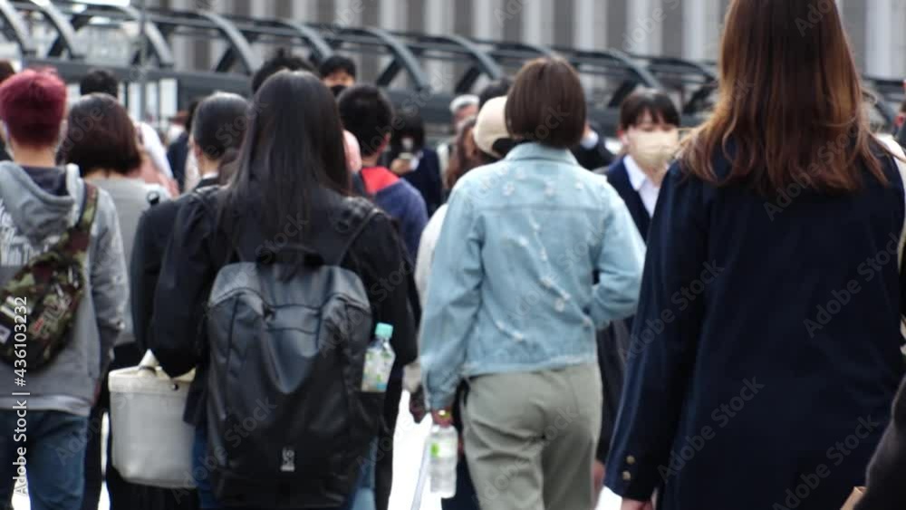 OSAKA, JAPAN - APRIL 2021 : Crowd of unidentified people wearing surgical masks to protect from Coronavirus (COVID-19) at busy downtown street. Slow motion shot. Focus in front. OSAKA, JAPAN - APRIL 2021 : Crowd of unidentified people wearing surgical masks to protect from Coronavirus (COVID-19) at busy downtown street. Slow motion shot. Focus in front.