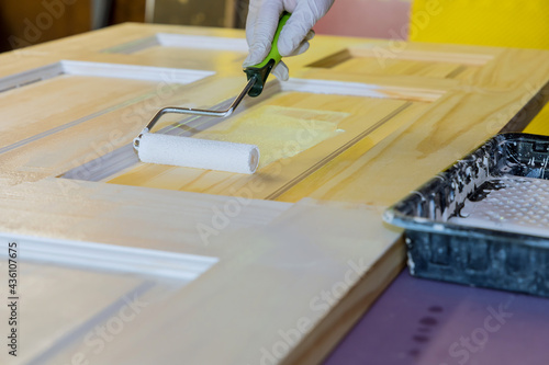 Repairman carpenter working painting a wooden door